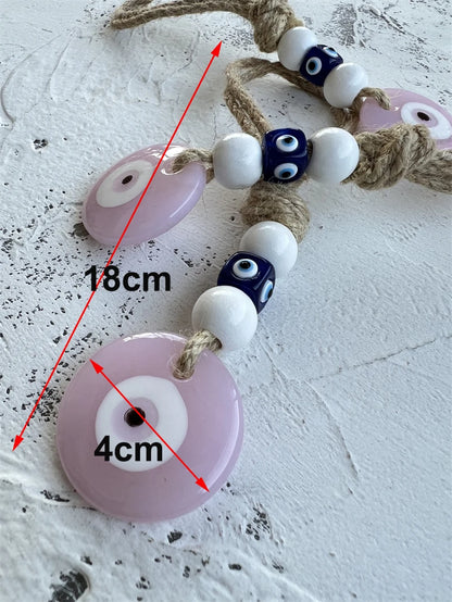 Decorative string with pink, white, and blue beads on a textured surface
