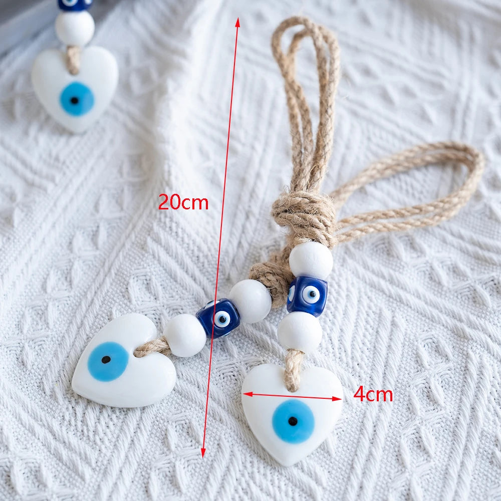 Heart-shaped evil eye charms with measurement markings on a textured white surface
