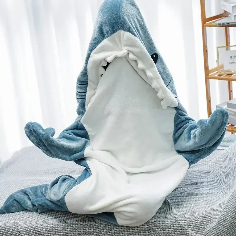 Person wearing a shark onesie sitting on a couch.