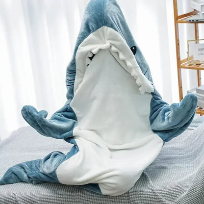 Person wearing a shark onesie sitting on a couch.