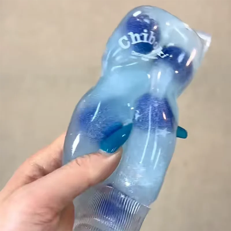 Blue plastic toy held by a hand against a beige background