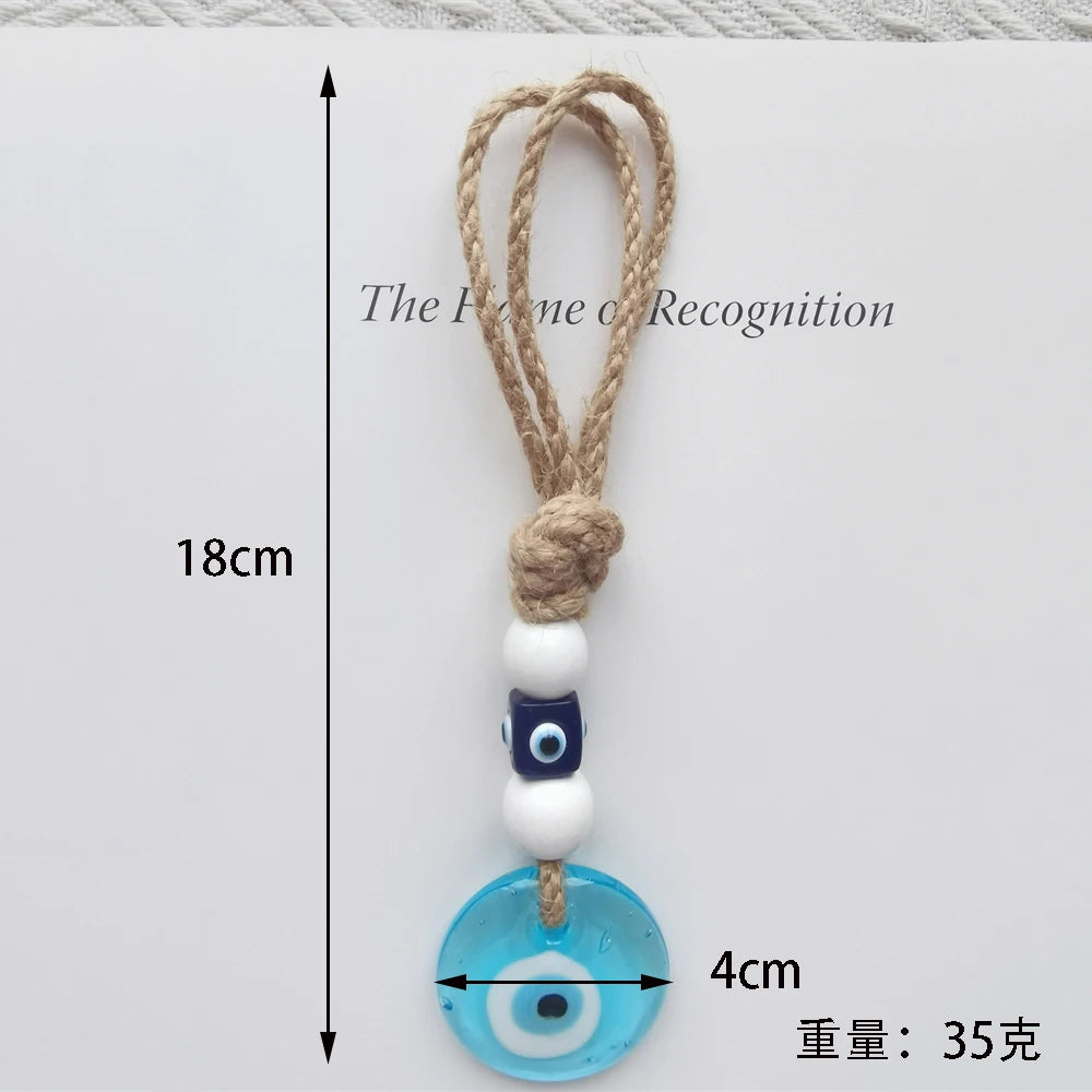 Decorative keychain with blue evil eye charm and measurement details on a white background