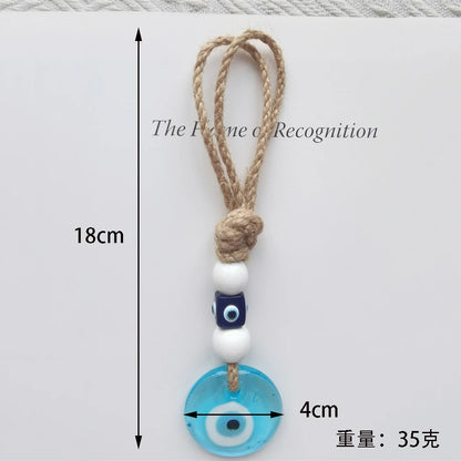 Decorative keychain with blue evil eye charm and measurement details on a white background
