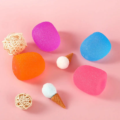 Colorful makeup sponges and ice cream cones on a pink background
