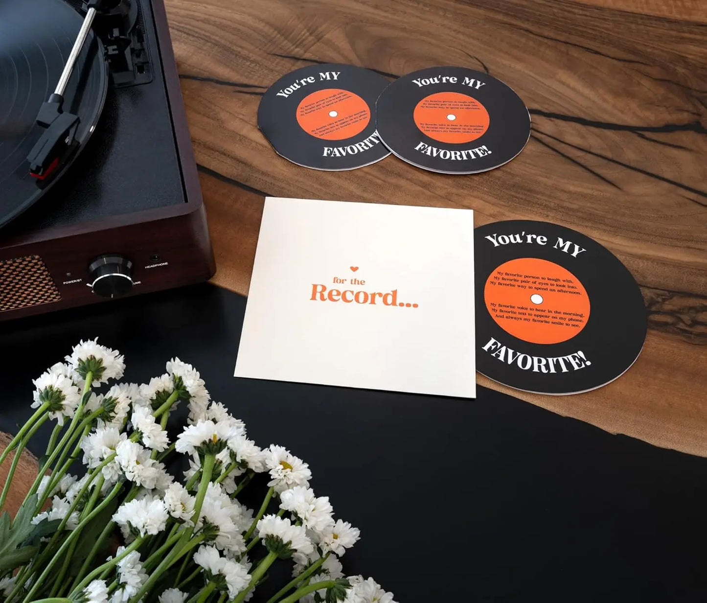 Record player with 'You're My Favorite' coasters and a card on a wooden surface.