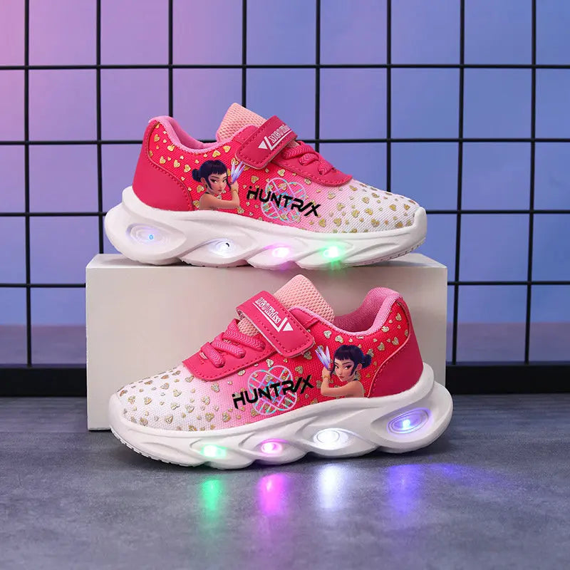 Pink children's sneakers with LED lights on a gray surface and grid background