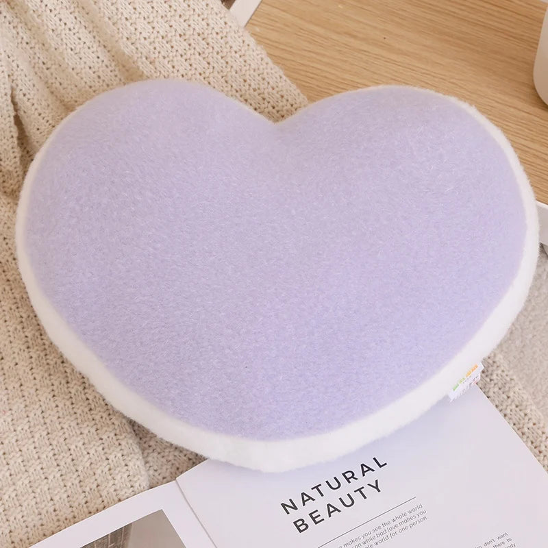 Heart-shaped purple cushion on a textured surface with 'Natural Beauty' magazine.