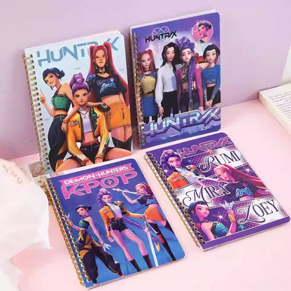 Four notebooks with colorful covers featuring characters and text on a pink surface.