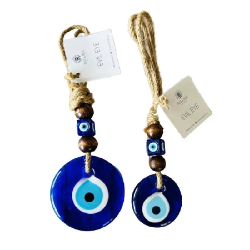 Two blue evil eye charms with brown and wooden beads on a white background