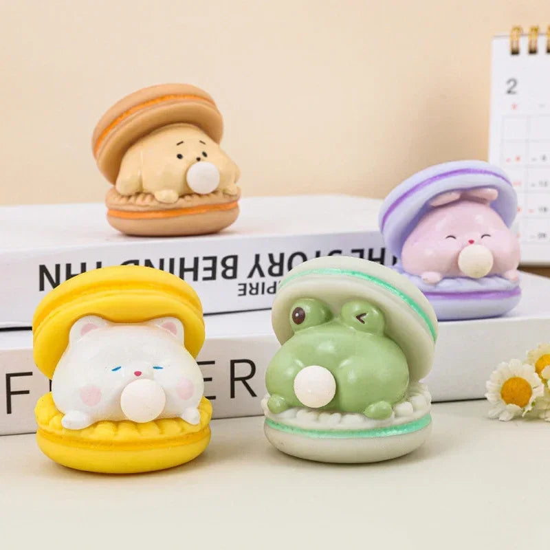 Four cute animal-themed desk toys on a surface with a calendar in the background.