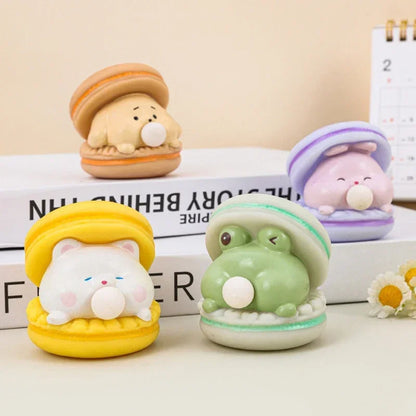 Four cute animal-themed desk toys on a surface with a calendar in the background.