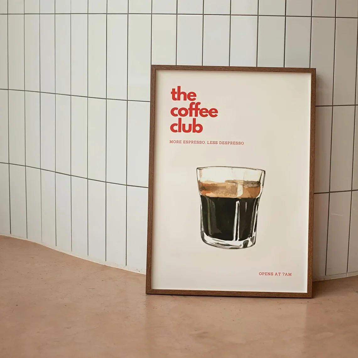 Framed poster of 'the coffee club' with a glass of coffee against a tiled wall.