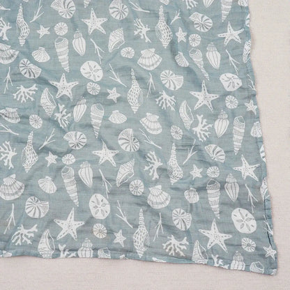 Blue fabric with white sea-themed pattern on a light gray background