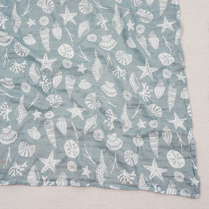 Blue fabric with white sea-themed pattern on a light gray background