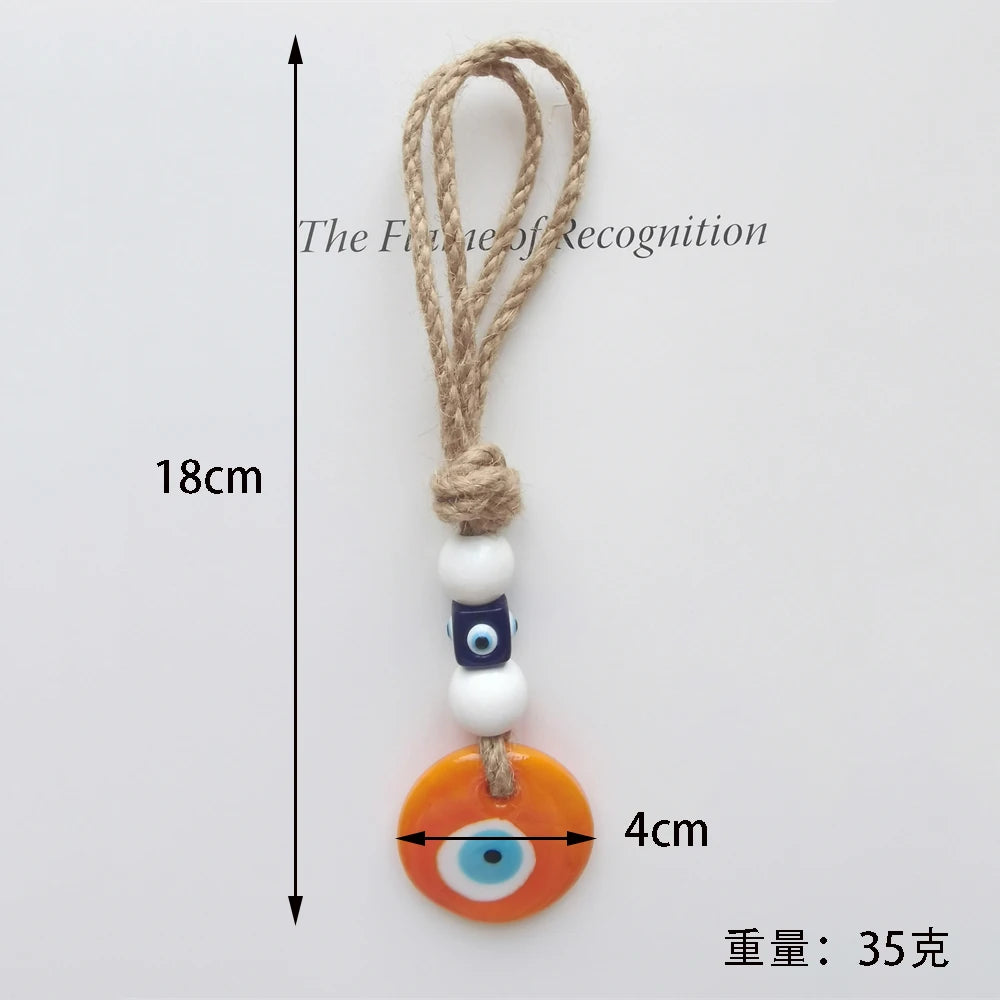 Measurement chart of a decorative keychain with an orange evil eye charm on a white background.