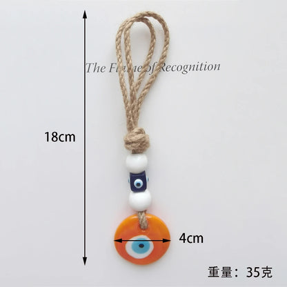 Measurement chart of a decorative keychain with an orange evil eye charm on a white background.