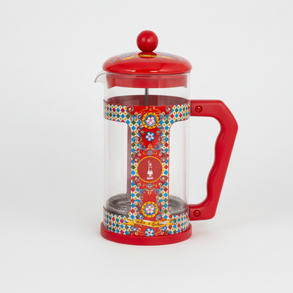 Red French press coffee maker with colorful design on a white background