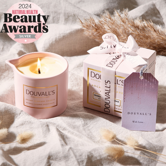 Douvall's candle and packaging on a soft surface with '2024 Natural Health Beauty Awards' text.