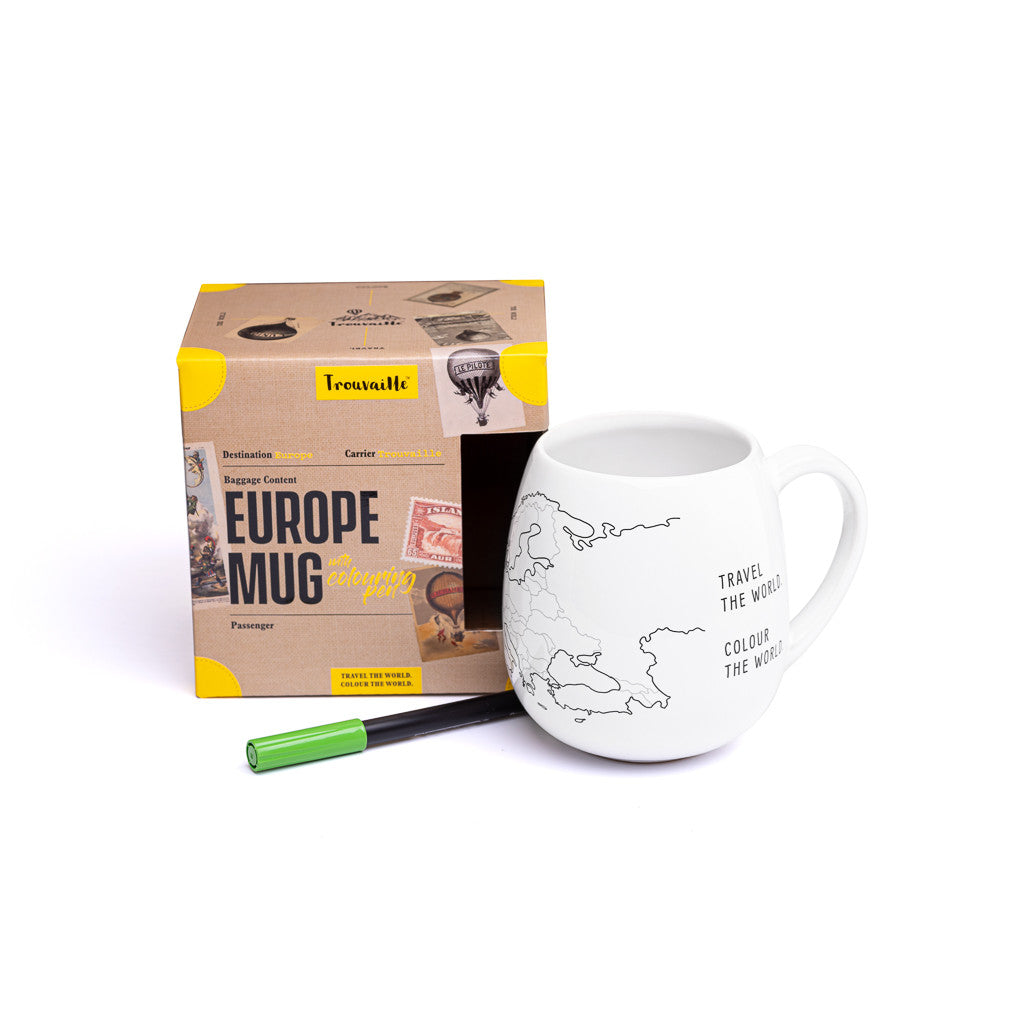 White mug with world map design and pen, next to Tassimo packaging on a white background