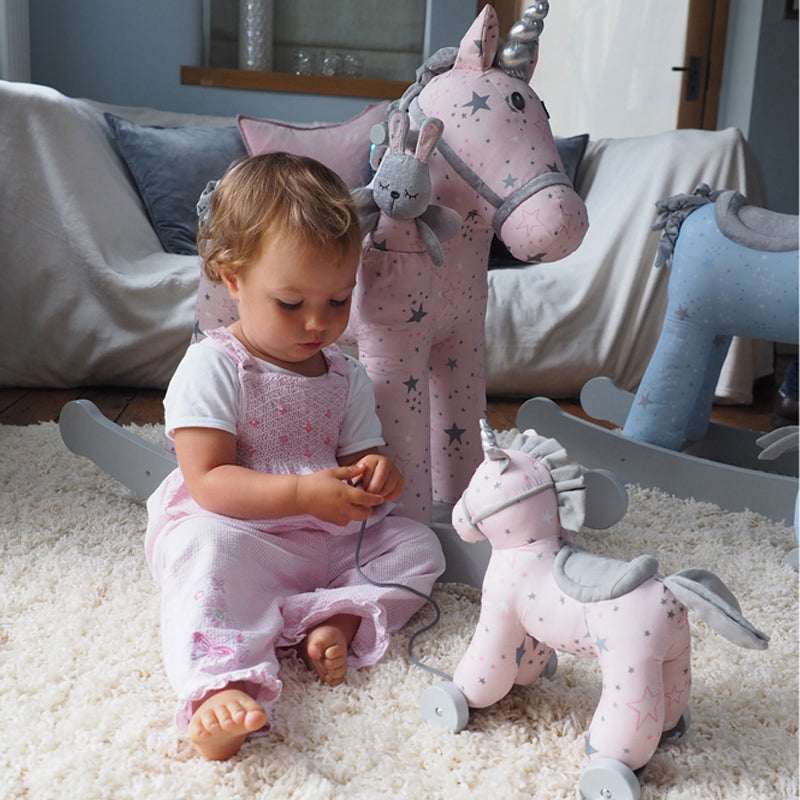 Child playing with plush toys on a carpeted floor