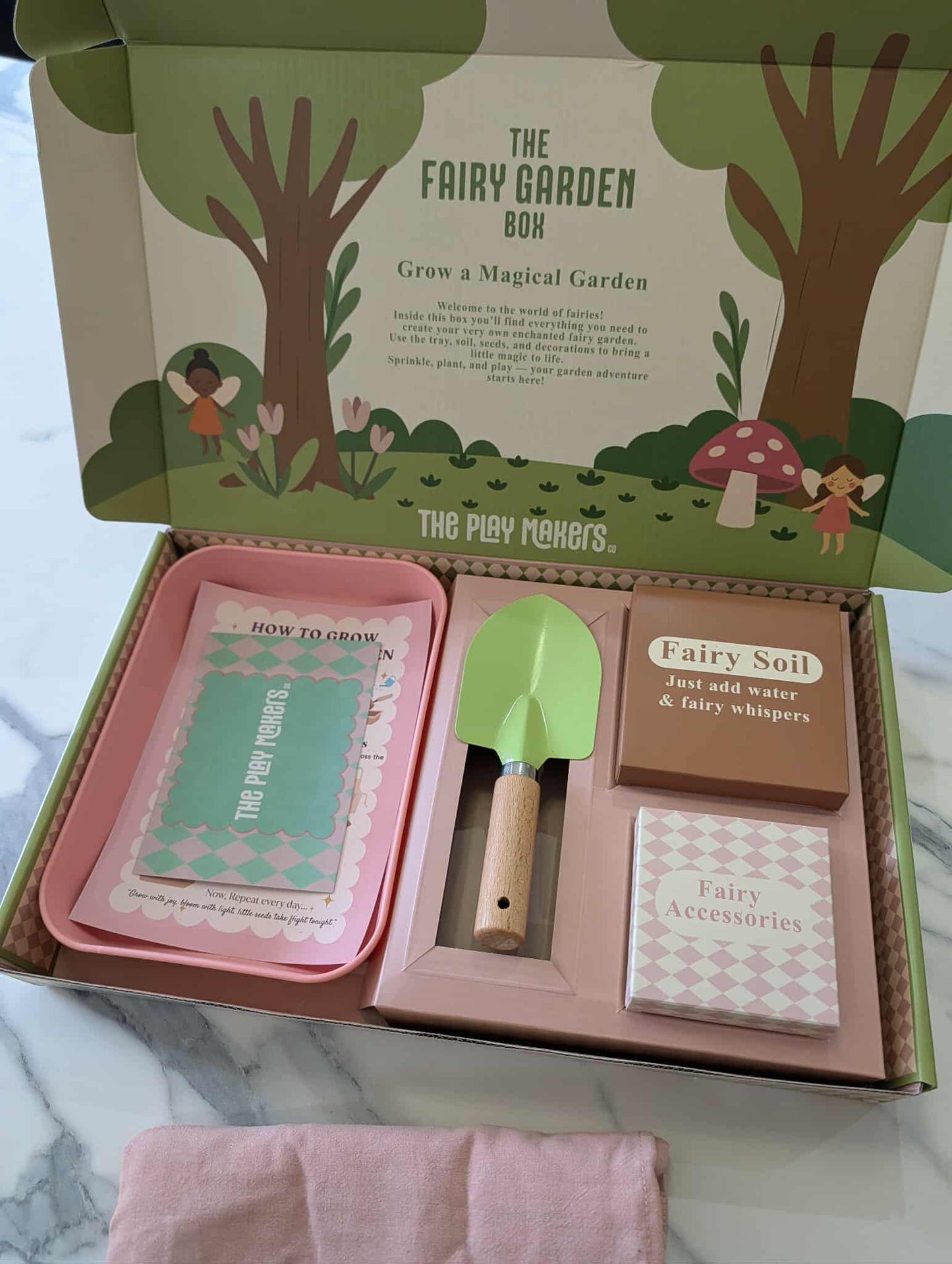 Fairy garden kit with tools and accessories in a box labeled 'The Fairy Garden Box'.