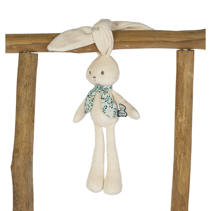 Stuffed bunny toy with a floral scarf hanging on wooden beams