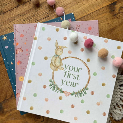 Book titled 'your first year' with a bunny illustration on a wooden surface.