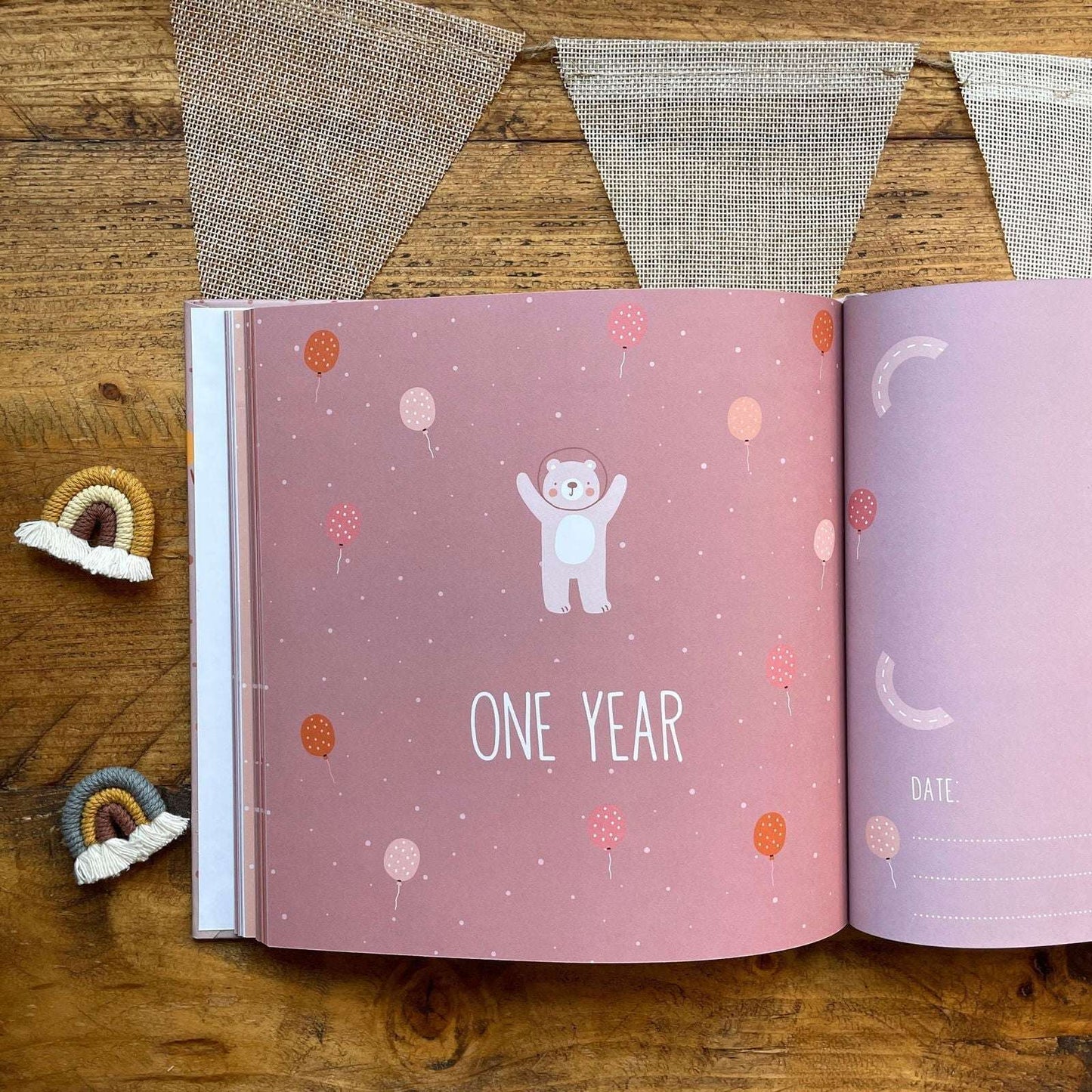 Open book with 'One Year' page on a wooden surface with decorative elements.