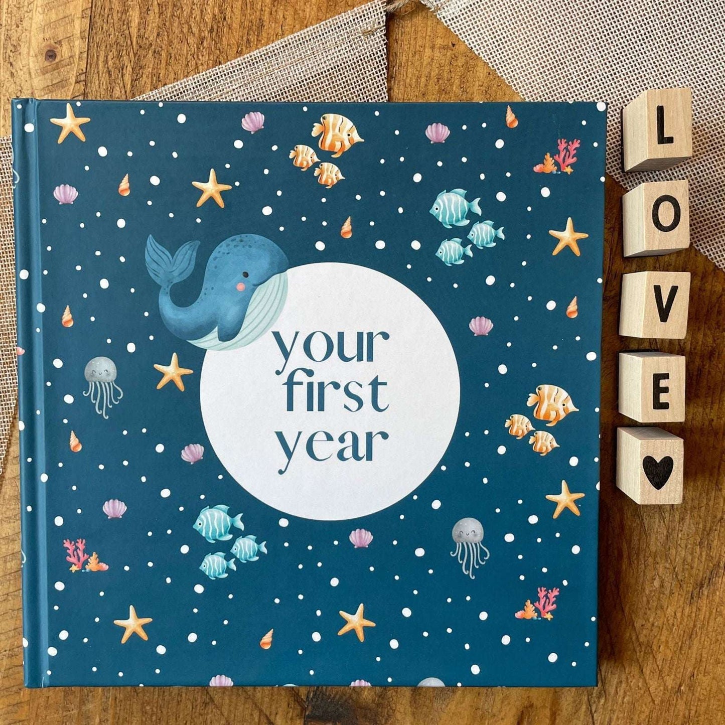 Book titled 'your first year' with whale illustration on a wooden surface