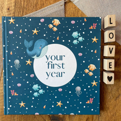 Book titled 'your first year' with whale illustration on a wooden surface