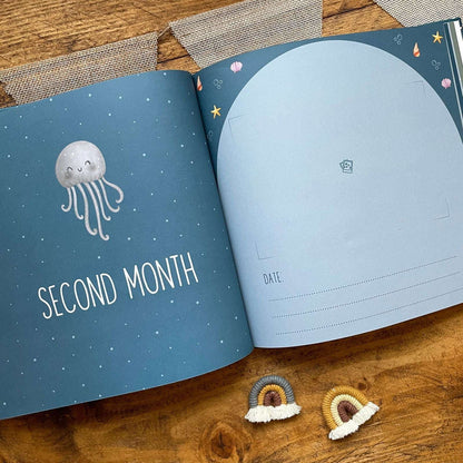 Open book with 'Second Month' and octopus illustration on a wooden surface
