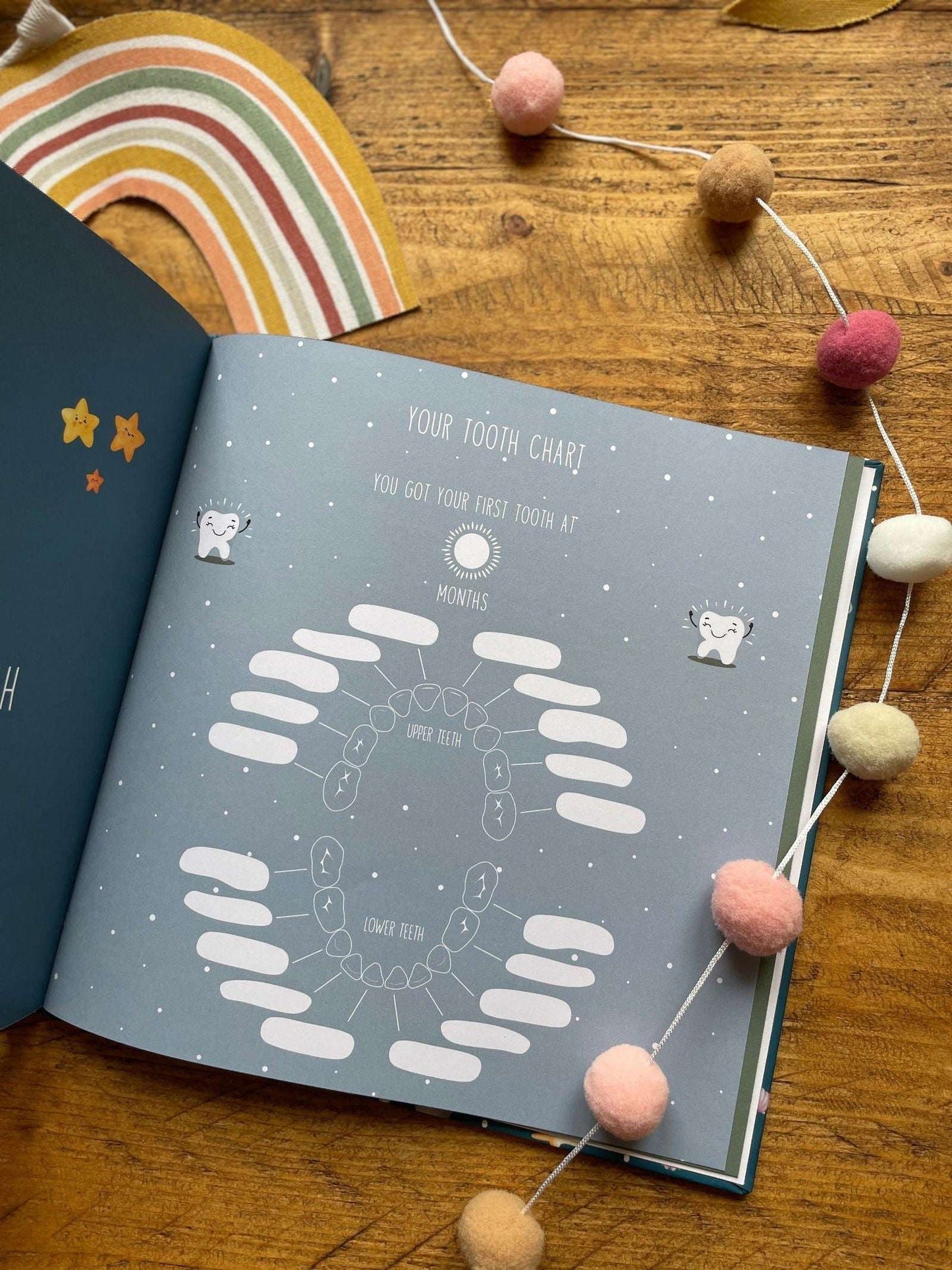 Children's tooth chart on a wooden surface with decorative elements