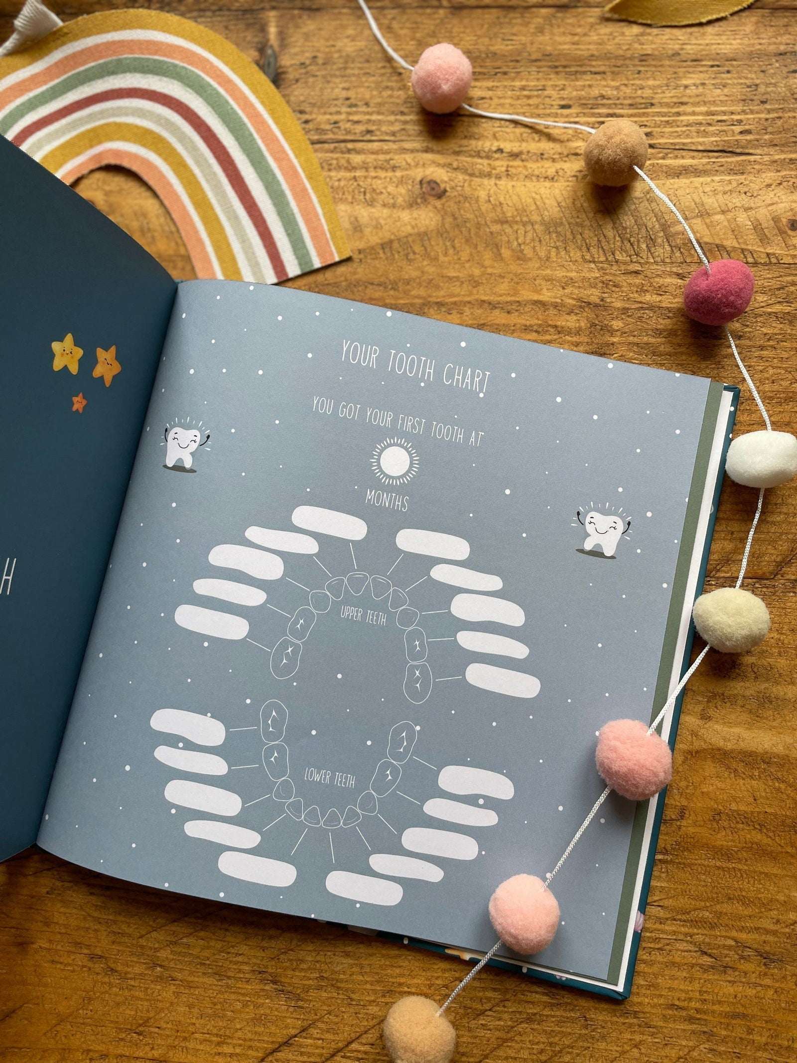 Children's tooth chart on a wooden surface with decorative elements