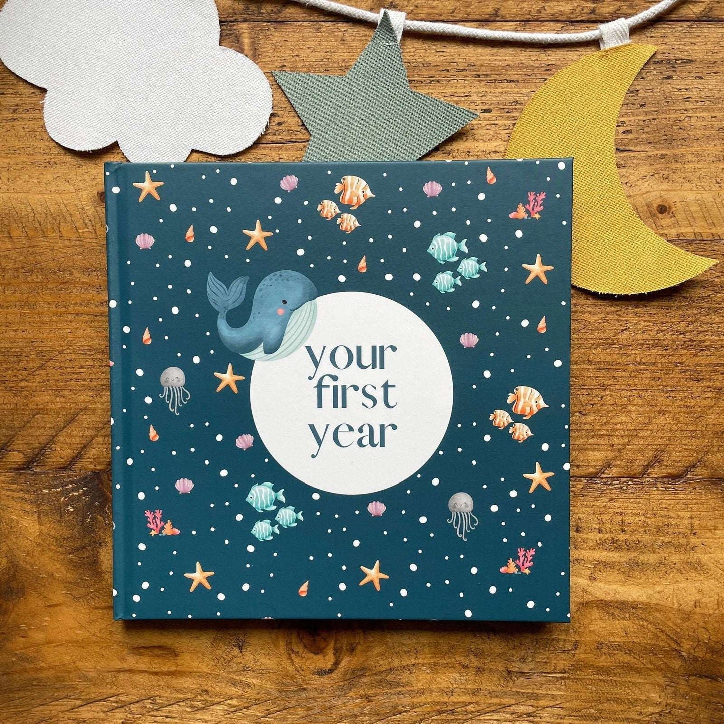 Book titled 'your first year' with whale illustration on a wooden surface