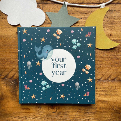 Book titled 'your first year' with whale illustration on a wooden surface