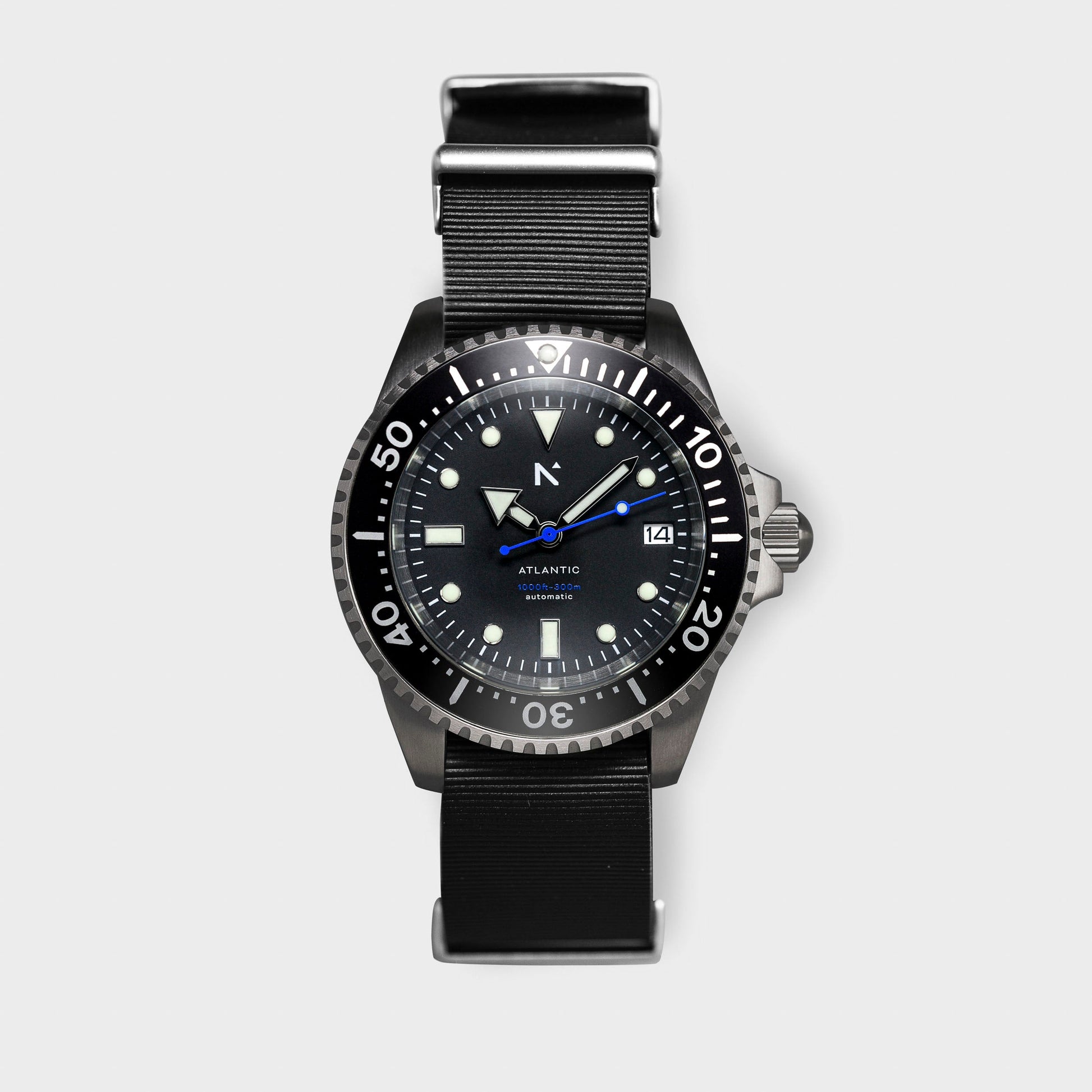 Black wristwatch with a detailed face on a light gray background