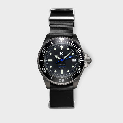 Black wristwatch with a detailed face on a light gray background