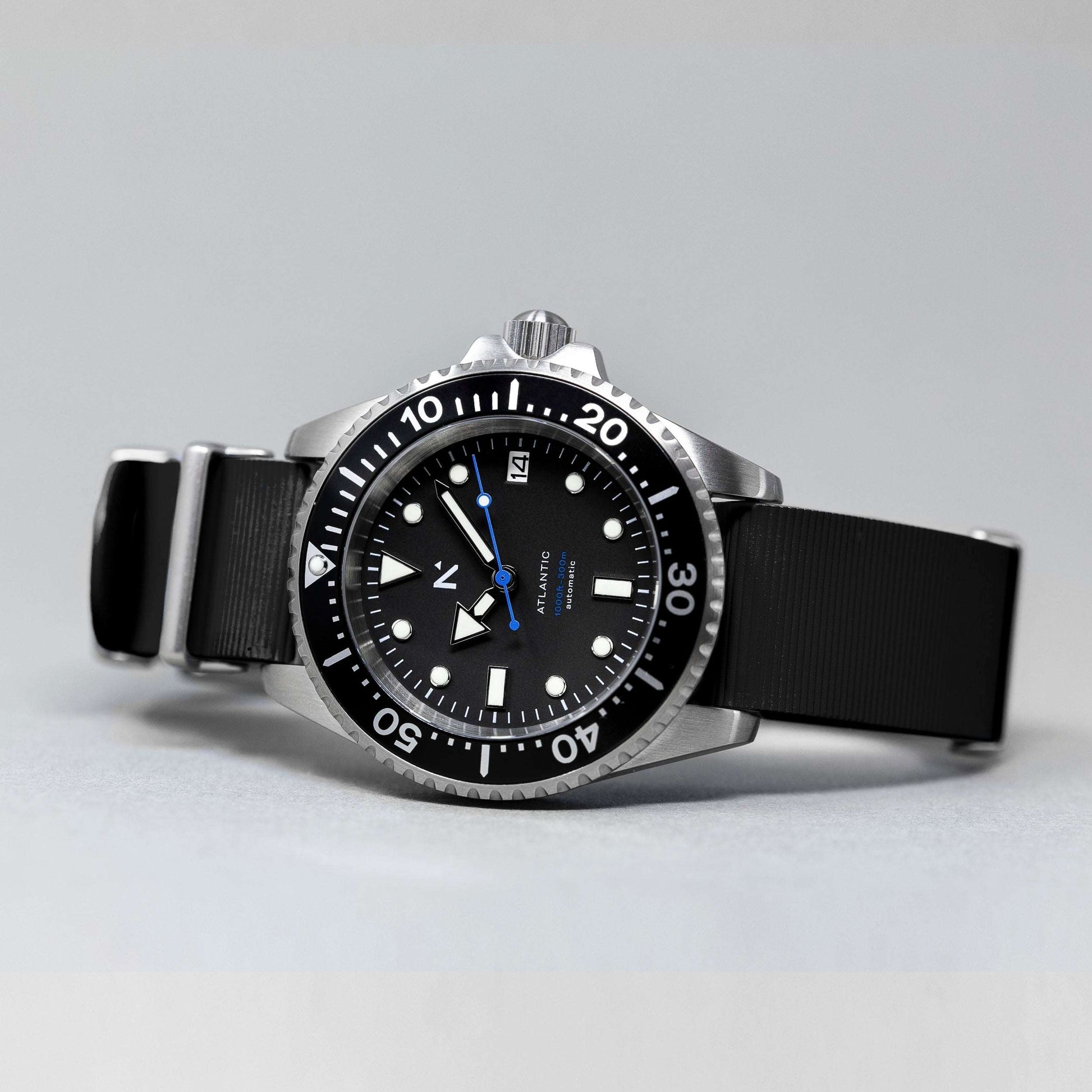 Black wristwatch with a detailed dial on a gray background