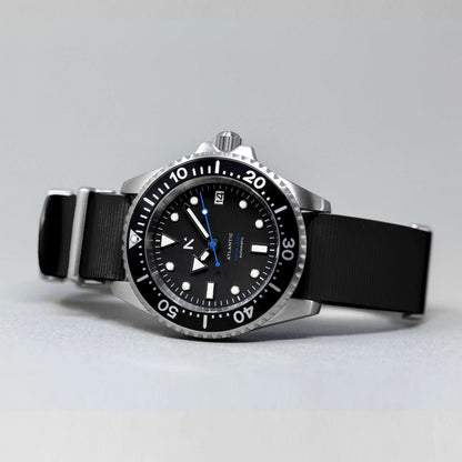 Black wristwatch with a detailed dial on a gray background
