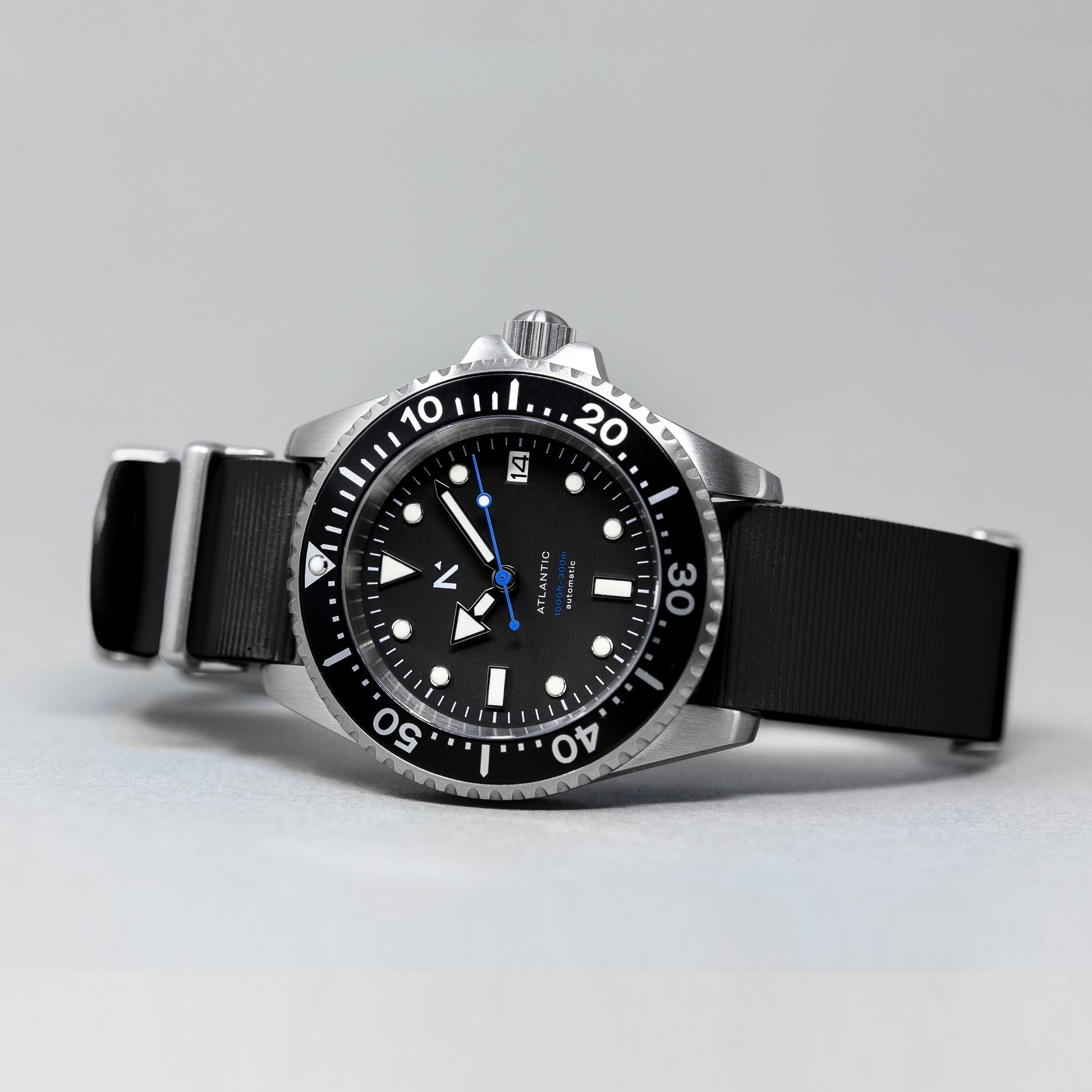 Black wristwatch with a detailed dial on a gray background