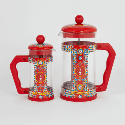 Two red and transparent coffee presses with colorful patterns on a white background