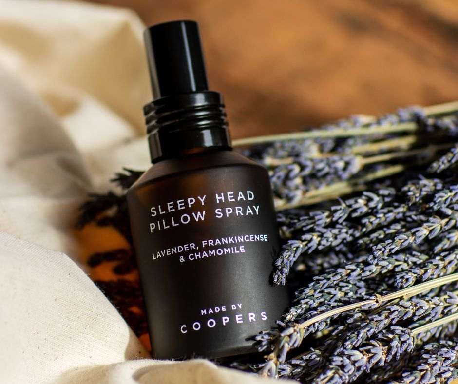 Sleepy Head Pillow Spray bottle with lavender and chamomile on a soft background