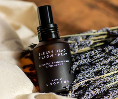 Sleepy Head Pillow Spray bottle with lavender and chamomile on a soft background