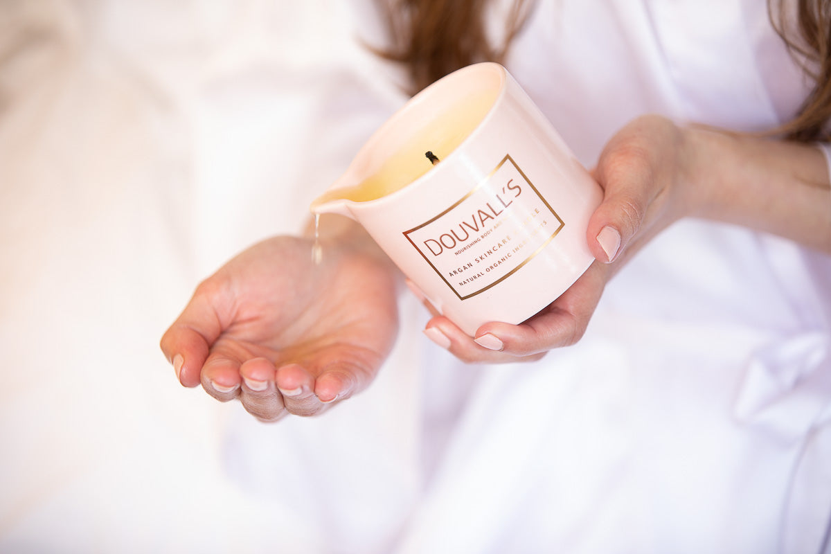 Person holding a Douvall's candle with a soft focus background