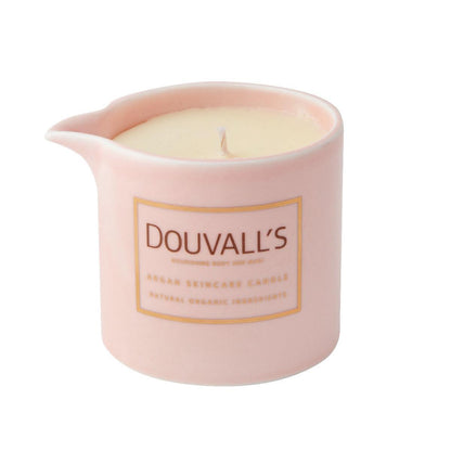 Pink ceramic candle holder with a lit candle inside on a white background, featuring the brand 'Douvall's'.