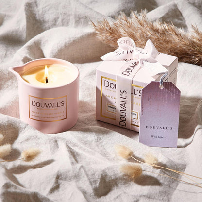 Douvall's candle and packaging on a soft fabric background