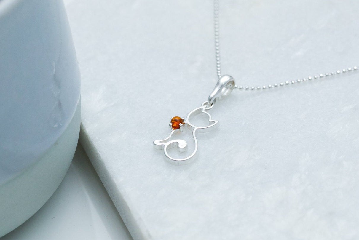 silver cat necklace on a marble stone background