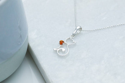 silver cat necklace on a marble stone background