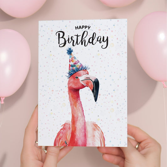 Birthday card with a flamingo wearing a party hat held by hands with balloons in the background