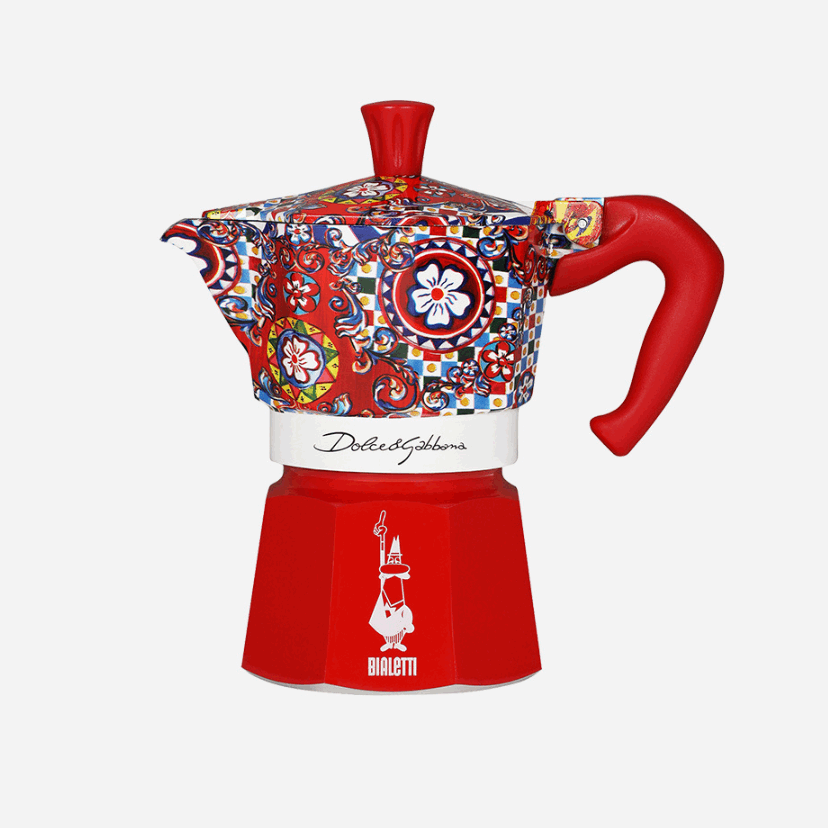 Decorative coffee maker with colorful pattern and red handle on a white background